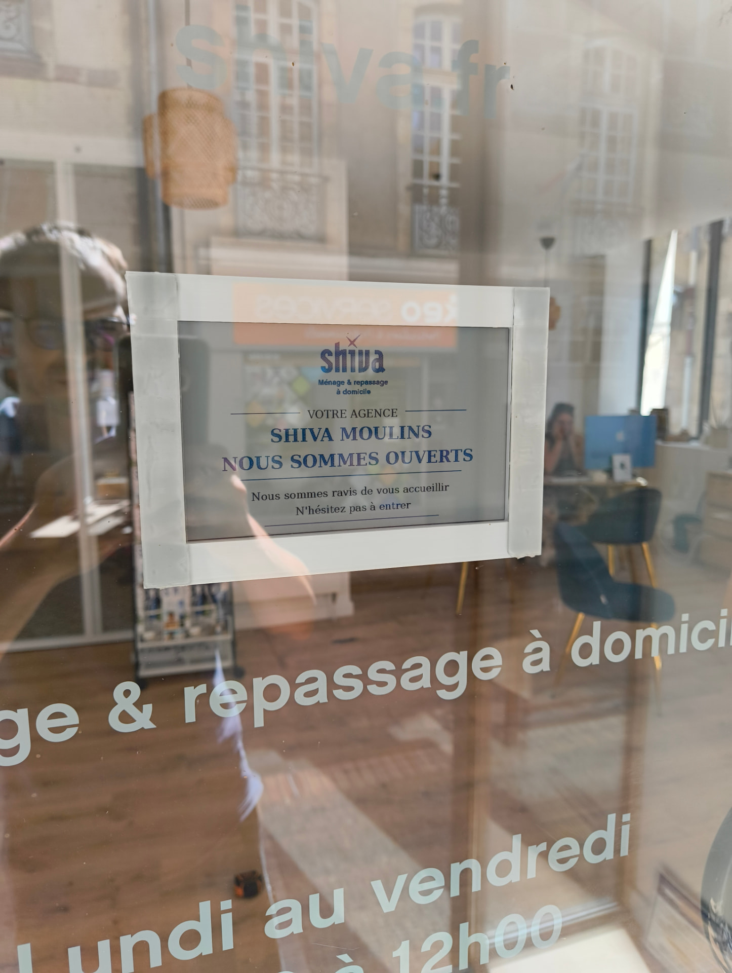 Terminal d'affichage connecté installé dans la vitrine de l'agence Shiva Moulins avec un support conçu sur mesure